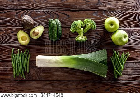 Green Vegetables Background. Сucumber, Avocado, Broccoli, Beans, Leek And Fresh Apple On Dark Wooden