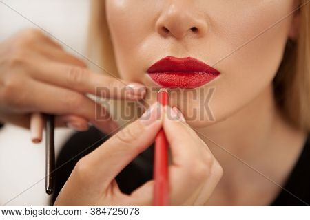 Cropped Shot Of A Makeup Artist Using Red Lip Pencil On The Lips Of A Woman