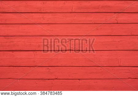 Fragment Of The Wall Of An Old Wooden House In Red. The Boards Are Arranged Horizontally, The Textur