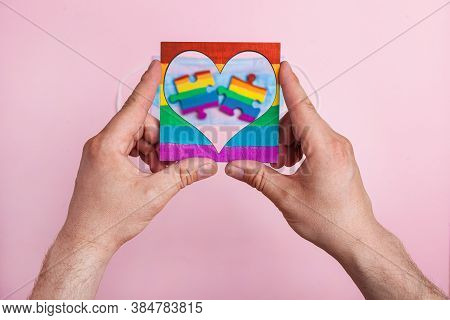 Lgbt Symbol Frame Heart In Male Hands Inside Puzzles Painted By A Rainbow On A Medical Mask. Coronav