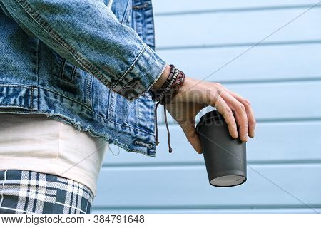 Hippie Woman Wearing Boho Leather Bracelets On A Wrist And Jeans Denim Jacket Holding A Takeaway Pap