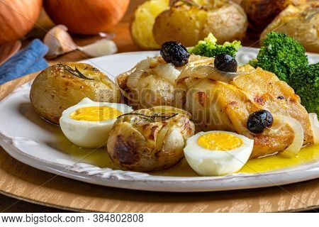 Cod Loin Baked In Olive Oil, With Potatoes, Broccoli, Boiled Egg And Black Olives. Typical Dish Of P