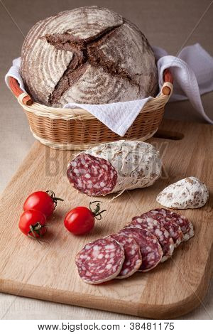 Skiver spegepølse om bord, cherrytomater brød i brødkurv