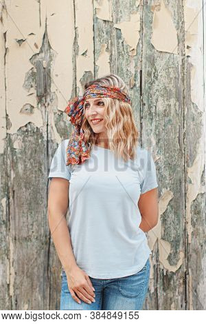 Young Women Wearing T-shirt And Jeans Stays Near An Old Wall