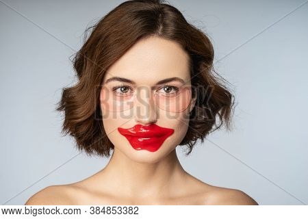 Charming Young Woman Using Collagen Lip Patch And Under-eye Patches