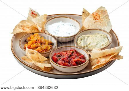 Top View On A Plate With Different Sauce Toppings And Chips Isolated On White