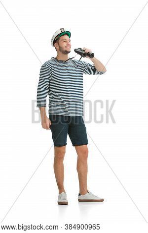 Holding Binocular. Caucasian Male Sailor In Uniform On White Studio Background. Young Man Using Mode