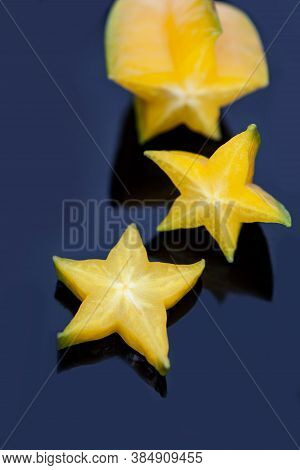 Exotic Starfruit Or Averrhoa Carambola  Siced On A Black Plate