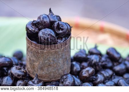 Close-up Of Waternut Or Chinese Water Chestnut For Sale In Market. Space For Text. Concept Of Fruits