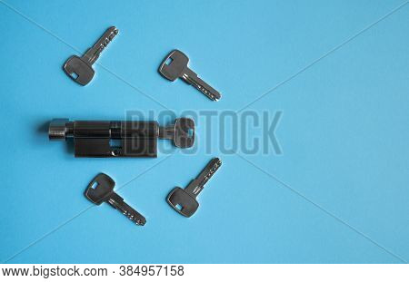 A Door Lock Cylinder Core With Keys On The Blue Background. The Cylinder Of The Lock With Keys. Inst