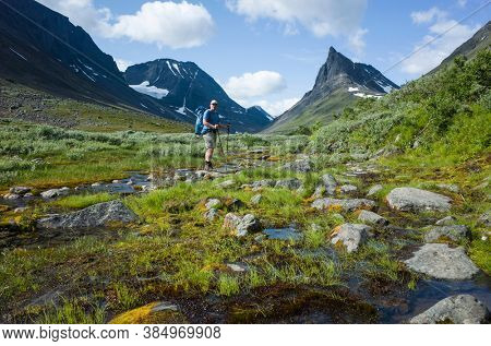 Hiking in Swedish Lapland. Man trekking alone in northern Sweden. View of Nallo mountain, Arctic nature of Scandinavia in summer day