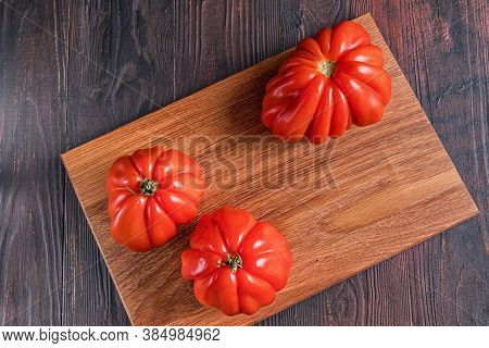 Close Up Of Red Ripe Tomatoes On A Wooden Board. Funny, Weird Vegetable. Ugly Food.