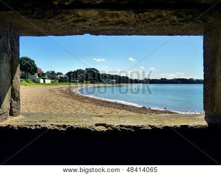 Mostra attraverso una finestra di bunker su una spiaggia
