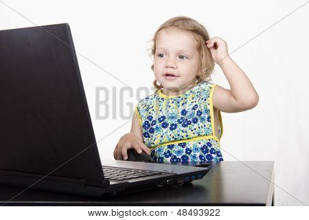 The girl sitting at the table and running laptop