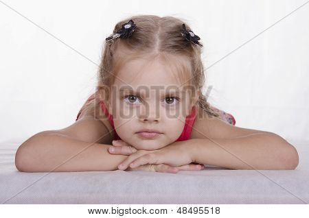 This girl has his head in his hands and looks into the frame