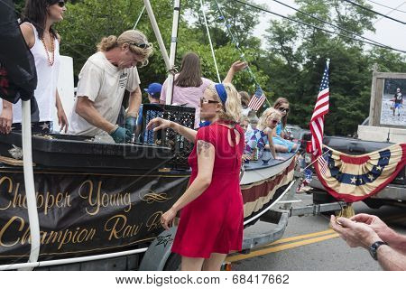 Man shucks oysters on a float in the Wellfleet 4th of July Parade in Wellfleet, Massachusetts.