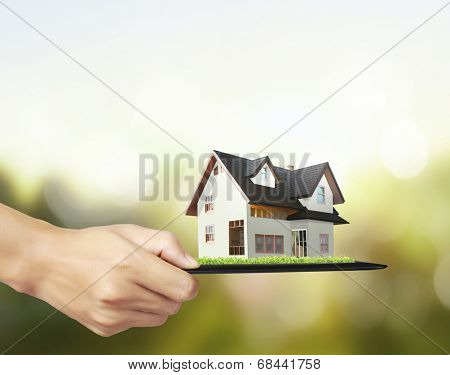 house on ,touch- tablet in a hands 
