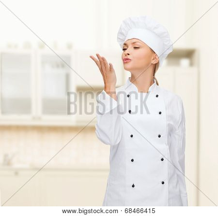 cooking, gesture and food concept - smiling female chef showing delicious gesture