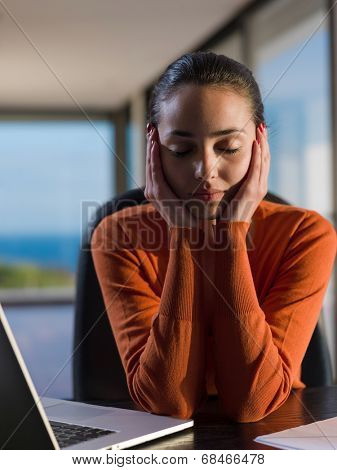 beautiful young woman relax and work on laptop computer while listening music on heaphones and read book at home