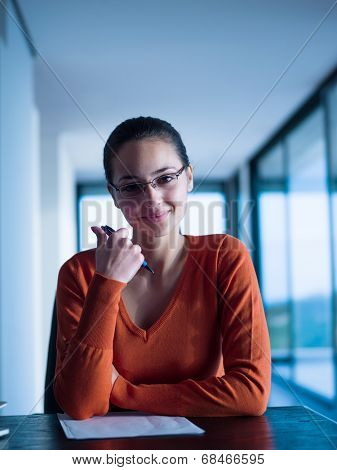 beautiful young woman relax and work on laptop computer while listening music on heaphones and read book at home