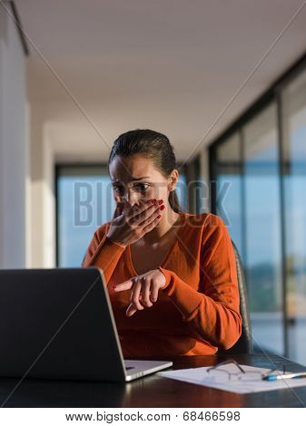 beautiful young woman relax and work on laptop computer while listening music on heaphones and read book at home