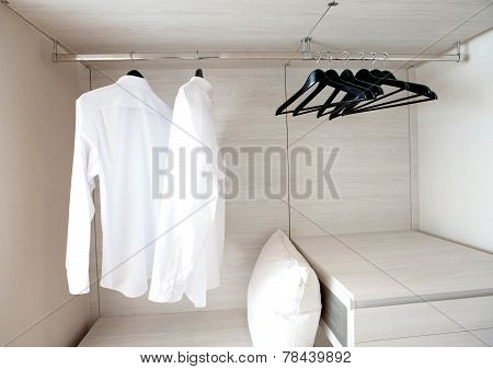 White Shirts Hanging On Built-in Cloths Racks, With Drawers And Other Accessories