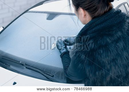 Winter Driving - Woman Scraping Ice from a Windshield