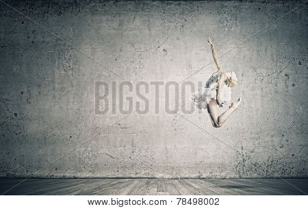 Young pretty ballerina girl making jump in dance