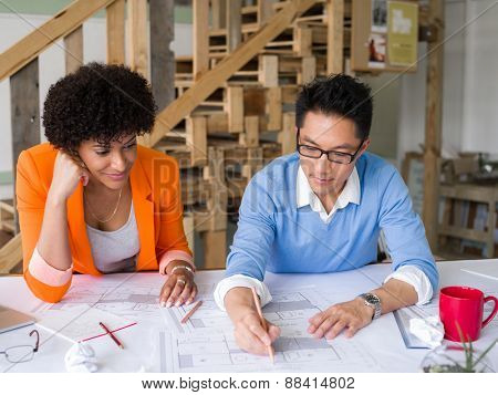 Two desingers working on a project together in office