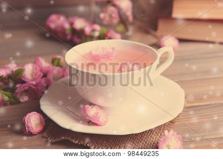 Cup of tea and beautiful fruit blossom on table