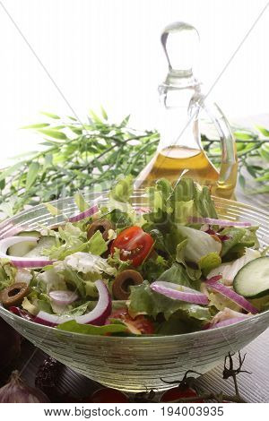Bowl Of Salad With Vegetables And Greens On Wooden Table