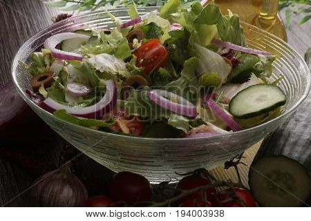 Bowl Of Salad With Vegetables And Greens On Wooden Table