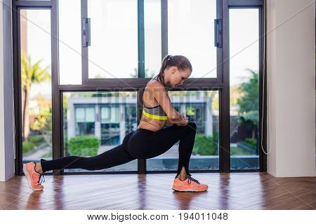 portrait of an athletic woman doing exercising abdominals work-out lying in gym at luxury hotel at summer.