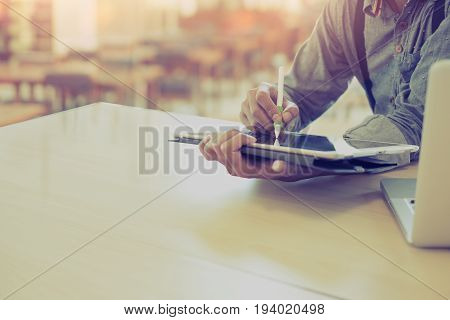 man sketchig with stylus on digital tablet pc in libraly. Creative idea people working with digitizer in the class.