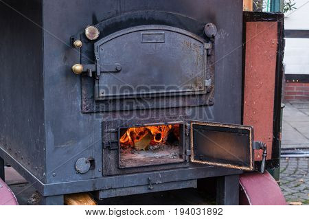 Interior fireplace in a corner with firewood and ax in an old country house