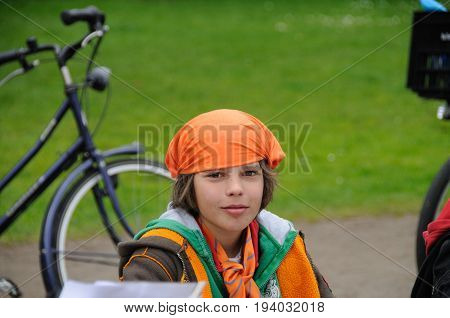 AMSTERDAM, NETHERLANDS - APRIL 30. Young boy dressed in orange Celebrating Queensday in Amsterdam. Queensday is a popular annual festival celebrating the Queens Birthday.
