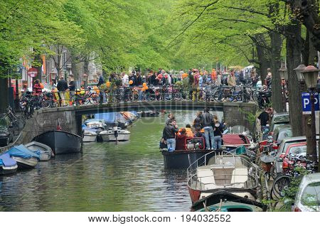 AMSTERDAM, NETHERLANDS - APRIL 30. Young People Celebrating Queensday in Amsterdam. Queensday is a popular annual festival celebrating the Queens Birthday.