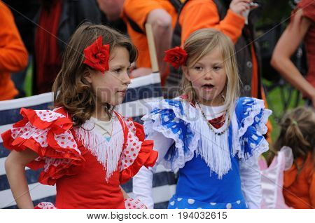 AMSTERDAM, NETHERLANDS - APRIL 30. Young girls dressed in red, white, and blue Celebrating Queensday in Amsterdam. Queensday is a popular annual festival celebrating the Queens Birthday.