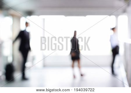 Blurred business people standing in building hall can be used as abstract background