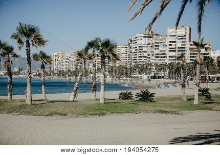 Malagueta beach in a sunny day, with deck chairs and umbrellas on the sand.