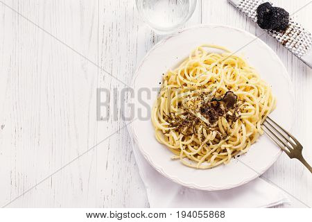 Strangozzi italian wheat pasta with truffle on a light background.