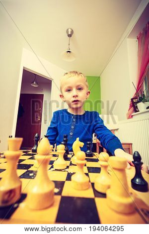 Intelligent smart ass kids games good for brain intelligence concept. Young kid boy playing chess and having fun.