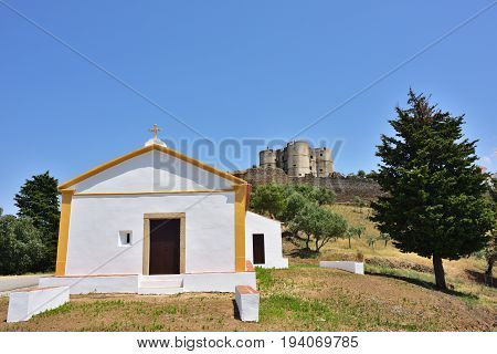 Beautiful view on the small white chapel and the Castle of Evoramonte on background. Initiated around 1306 it was enlarged in the later centuries in the Manueline style.