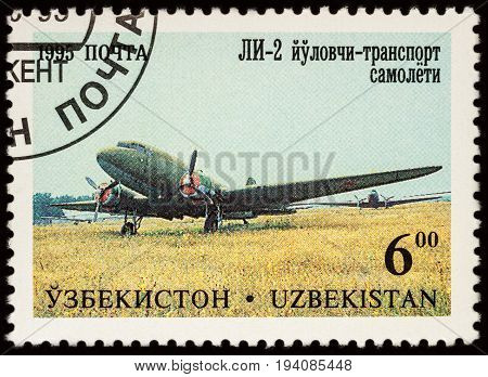 Moscow Russia - July 05 2017: A stamp printed in Uzbekistan shows airplane Lisunov LI-2 series "Aircraft of Tashkent's Aircraft Factory" circa 1995