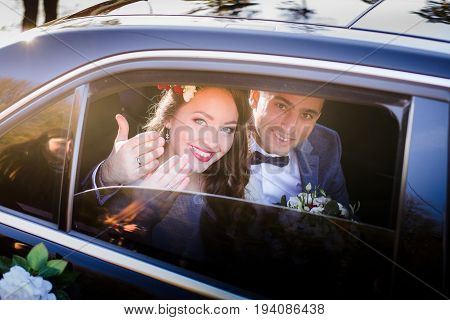 Happy Newlyweds Show Their Hands With Wedding Rings Through Car's Window