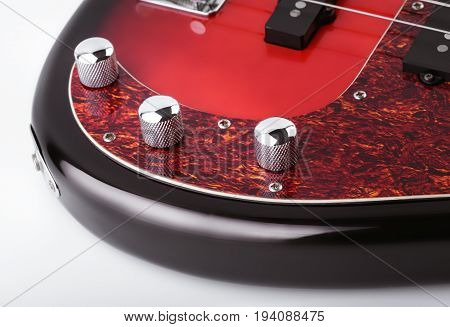Metallic volume treble guitar bass knobs. Electric guitar. Red electric bass guitar close-up. Musical instrument. Music. Four strings. Grif.