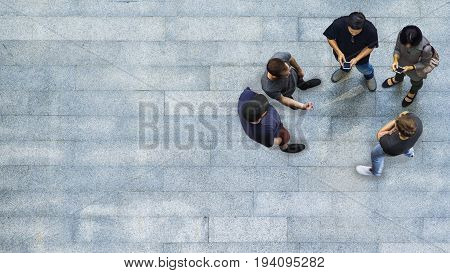 top view group of people are playing and talking with the smart phone on the concrete pedestrian (Aerial view)