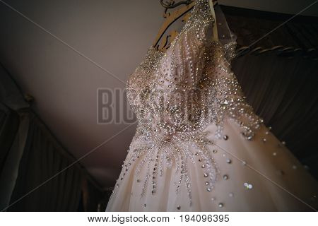 Wedding dress on hanger on a wall.