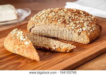 Delicious wheat-rye sourdough bread. Homemade whole grain bread sprinkled with oat flakes closeup