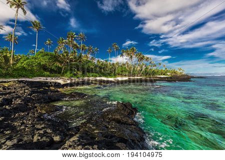 Beach with coral reef and black volcanic rocks on south side of Upolu, Samoa Islands